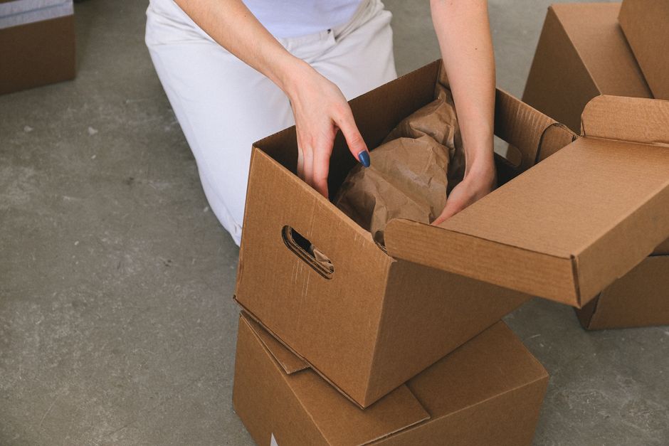Professional packers securing belongings in cardboard boxes